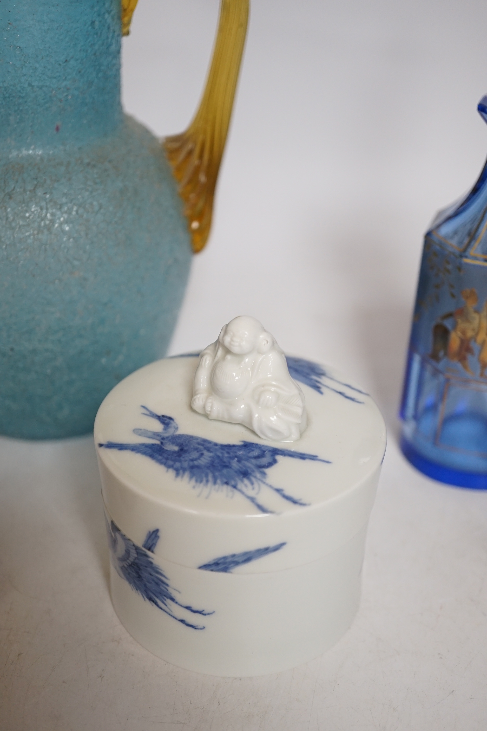 A 19th century Japanese Hirado blue and white cylindrical box and cover, height 8cms, a gold classically decorated glass bottle and a frosted glass jug and wooden pot (4)